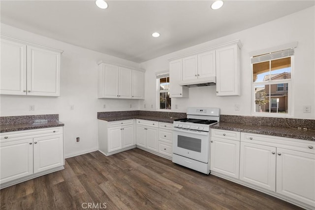 kitchen with white cabinetry, dark wood-type flooring, white range with gas cooktop, and dark stone counters