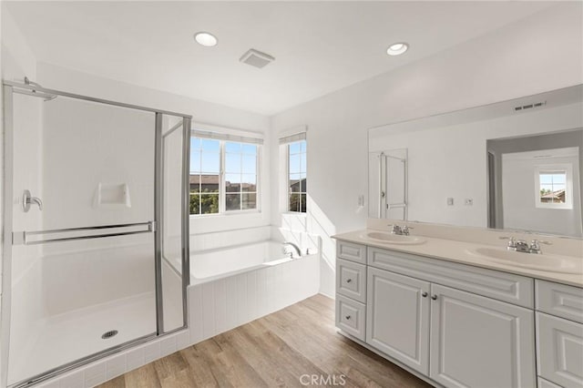 bathroom with vanity, hardwood / wood-style floors, and plus walk in shower