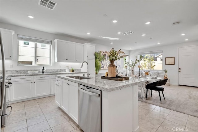 kitchen featuring light carpet, a center island with sink, white cabinets, sink, and stainless steel appliances