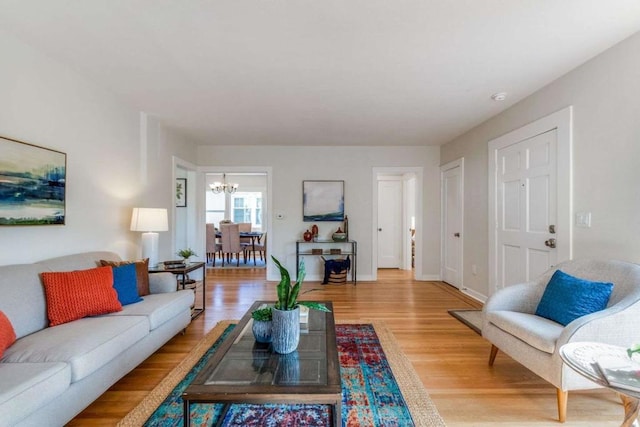 living room with hardwood / wood-style floors and an inviting chandelier