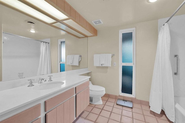 full bathroom featuring tile patterned flooring, vanity, toilet, and shower / tub combo