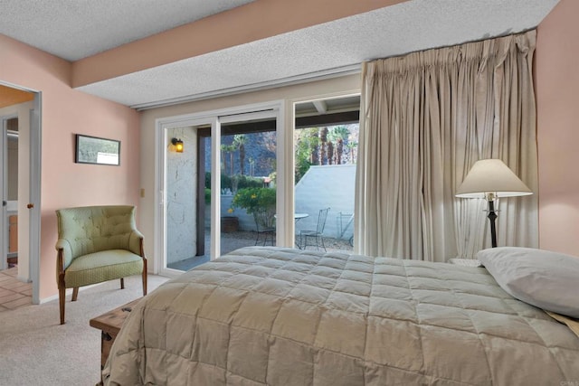 bedroom with carpet, a textured ceiling, and access to outside