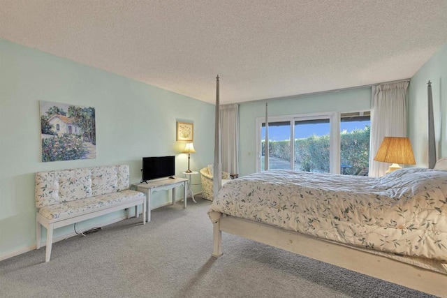 bedroom with access to exterior, carpet, and a textured ceiling