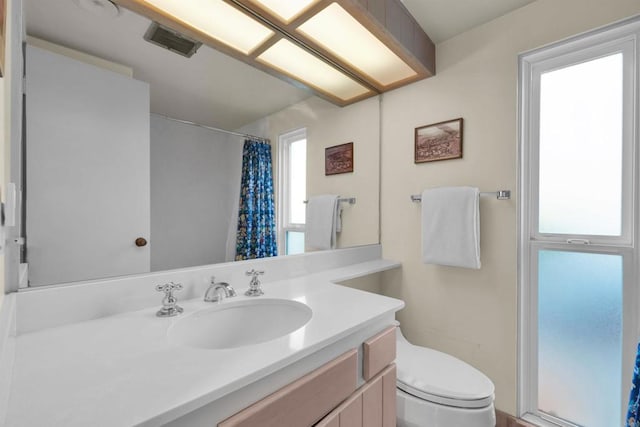 bathroom featuring a shower with curtain, vanity, and toilet