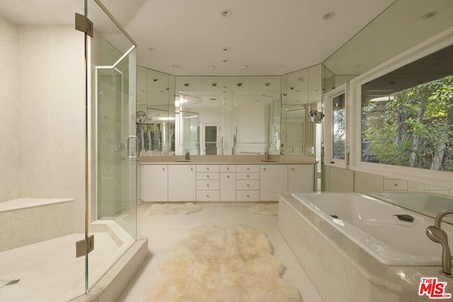 bathroom with vanity, tile patterned flooring, and plus walk in shower