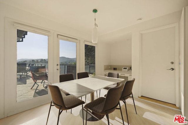 dining space featuring a mountain view, french doors, and light hardwood / wood-style flooring