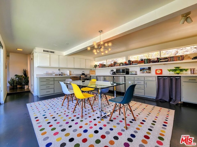 dining space featuring beamed ceiling, sink, and a chandelier