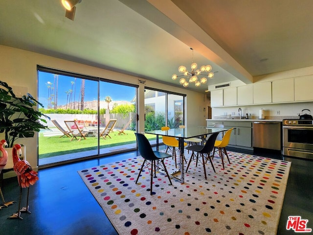 dining area featuring concrete flooring, sink, and a chandelier