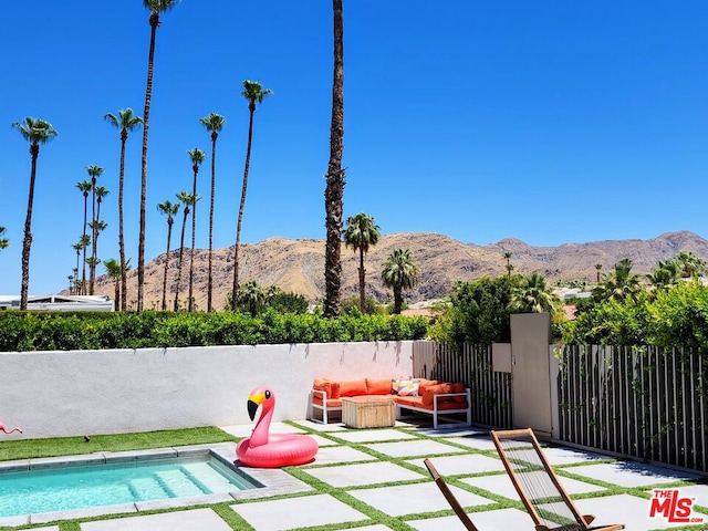 view of swimming pool featuring a mountain view, an outdoor hangout area, and a patio area