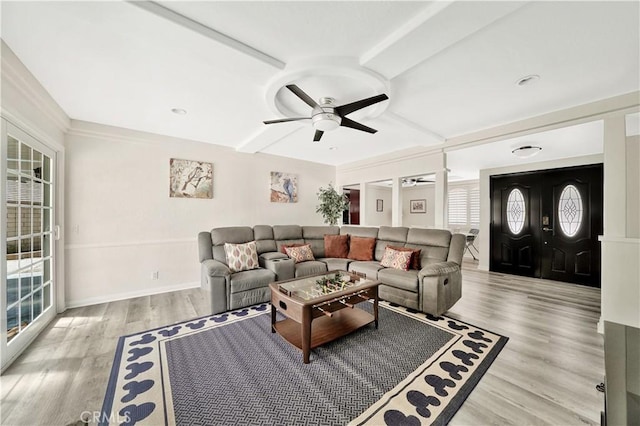 living room featuring ceiling fan, beam ceiling, and light wood-type flooring