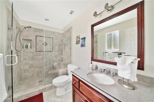 bathroom with vanity, tile patterned floors, toilet, and a shower with shower door