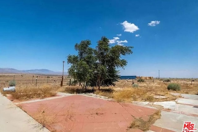 view of yard with a mountain view and a rural view