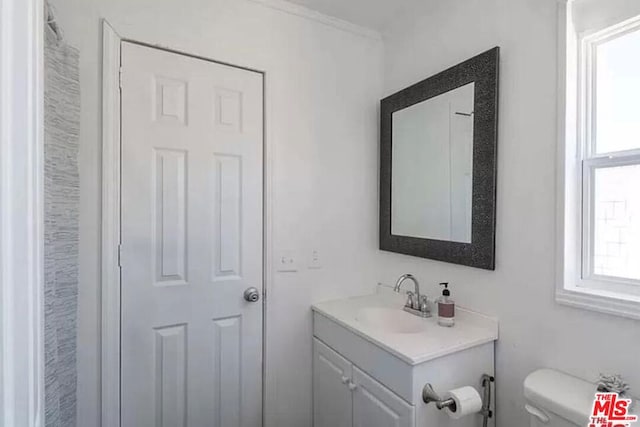 bathroom with vanity, toilet, a wealth of natural light, and ornamental molding