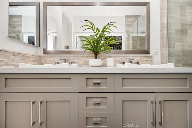 bathroom featuring decorative backsplash, vanity, and a shower with shower door