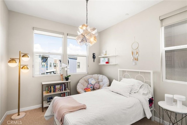 carpeted bedroom featuring an inviting chandelier