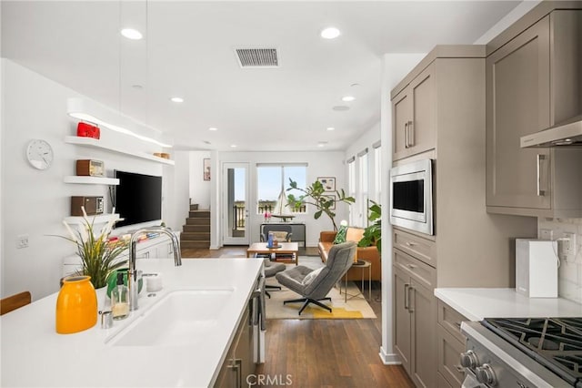 kitchen with stainless steel microwave, sink, wall chimney exhaust hood, and dark hardwood / wood-style floors