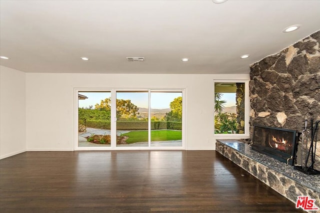 unfurnished living room featuring a premium fireplace and dark hardwood / wood-style floors