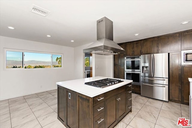 kitchen featuring dark brown cabinets, a kitchen island, range hood, and appliances with stainless steel finishes