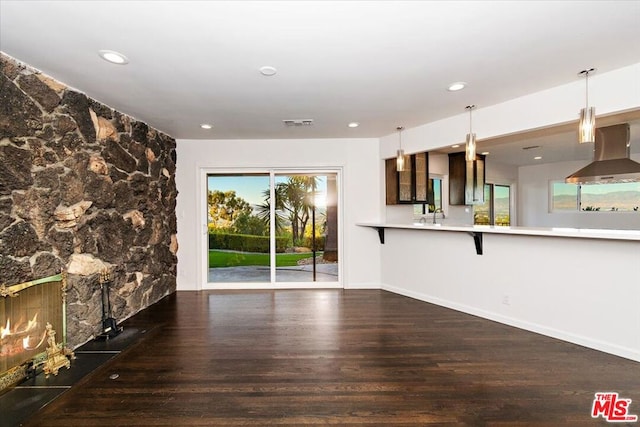 unfurnished living room with a premium fireplace, sink, and dark hardwood / wood-style floors