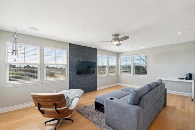 living room featuring light wood-type flooring, a wealth of natural light, and ceiling fan