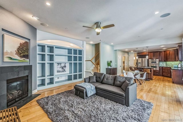 living room featuring ceiling fan, sink, and light hardwood / wood-style flooring