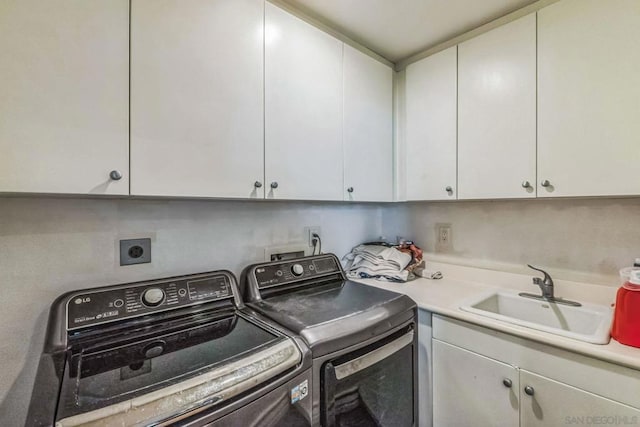 laundry area with cabinets, washer and clothes dryer, and sink