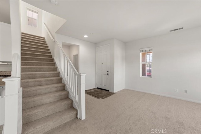 entryway with light colored carpet