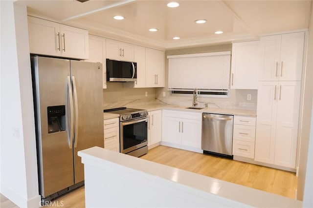 kitchen featuring white cabinetry, light hardwood / wood-style flooring, stainless steel appliances, and sink