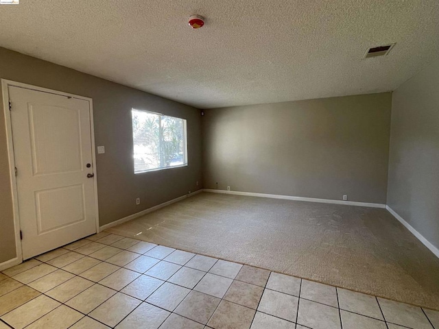 carpeted entryway featuring a textured ceiling