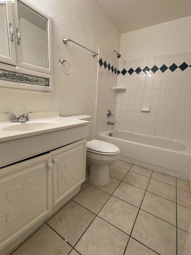 full bathroom featuring toilet, vanity, tiled shower / bath combo, and tile patterned floors