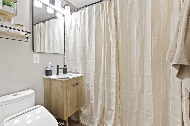 bathroom featuring vanity, toilet, and walk in shower