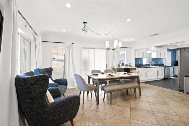 tiled dining room featuring a notable chandelier and sink