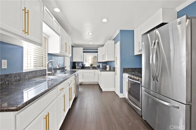 kitchen with dark hardwood / wood-style flooring, white cabinets, stainless steel appliances, and plenty of natural light