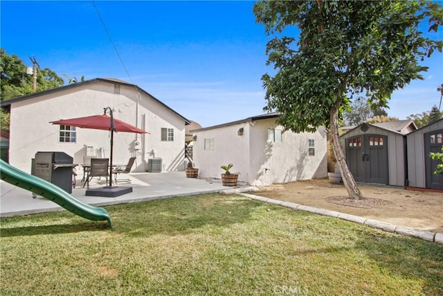 rear view of house featuring a playground, central AC unit, a shed, and a yard