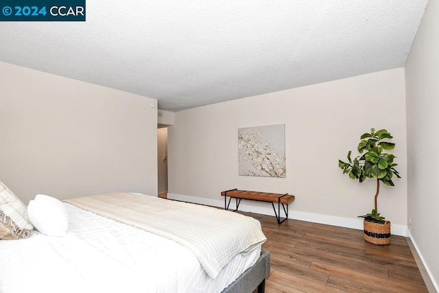 bedroom featuring a textured ceiling and hardwood / wood-style flooring