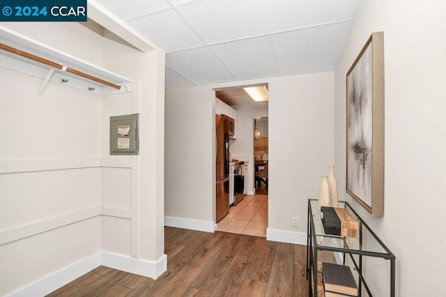 corridor featuring hardwood / wood-style floors and a paneled ceiling