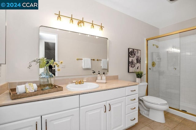 bathroom featuring tile patterned floors, toilet, vanity, and walk in shower