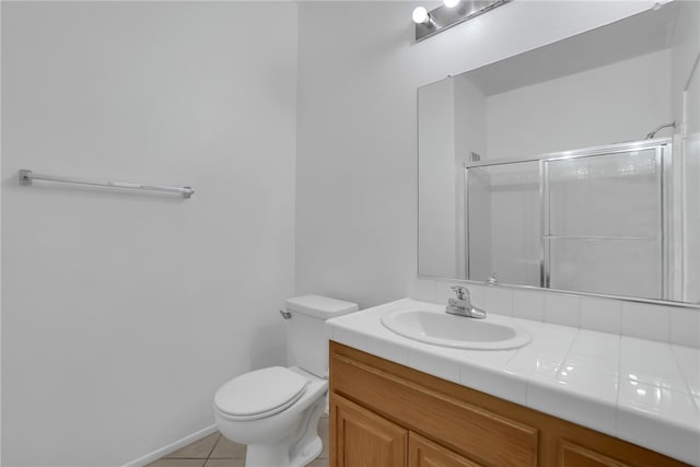 bathroom with tile patterned floors, toilet, vanity, and walk in shower