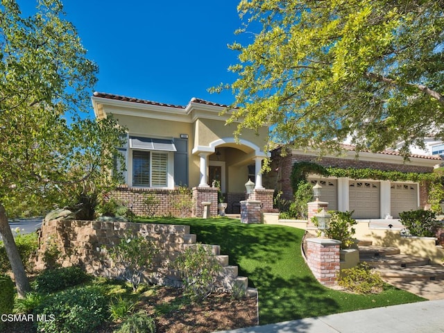 mediterranean / spanish-style house featuring a garage and a front yard