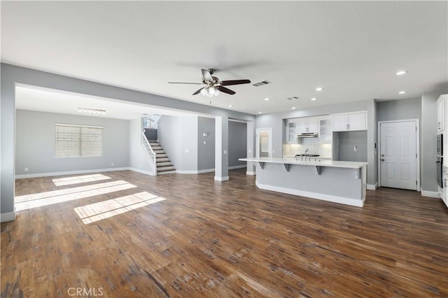 unfurnished living room featuring dark hardwood / wood-style floors and ceiling fan