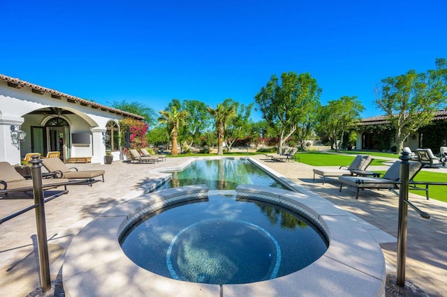 view of swimming pool featuring a yard, a patio area, and an in ground hot tub