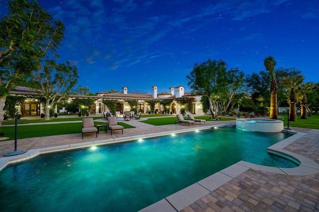 view of swimming pool featuring an in ground hot tub, a lawn, and a patio