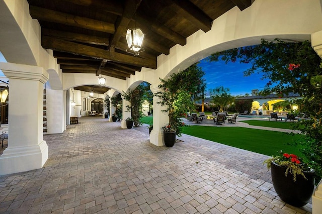 patio terrace at dusk featuring a pool and a yard