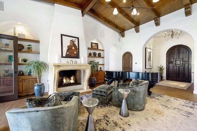 living room featuring built in features, high vaulted ceiling, wood ceiling, light hardwood / wood-style floors, and beam ceiling