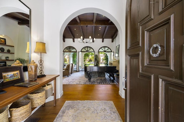 entryway with wood ceiling, a chandelier, dark wood-type flooring, and beamed ceiling