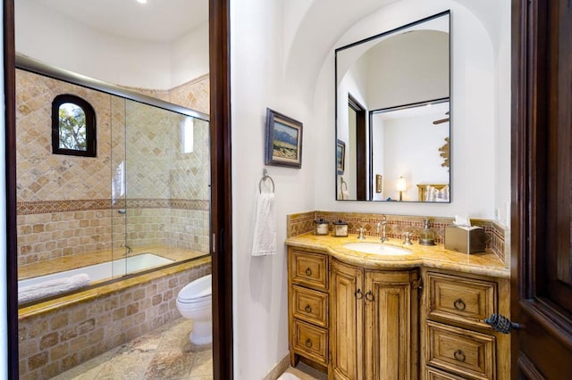 full bathroom with vanity, toilet, and combined bath / shower with glass door