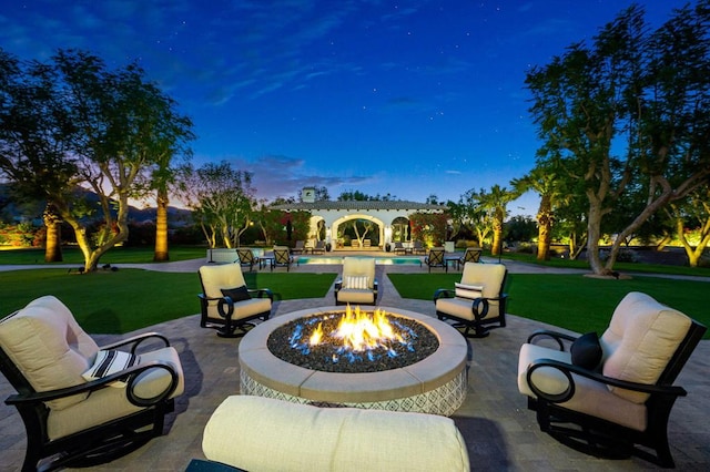 patio terrace at dusk with a lawn and an outdoor fire pit