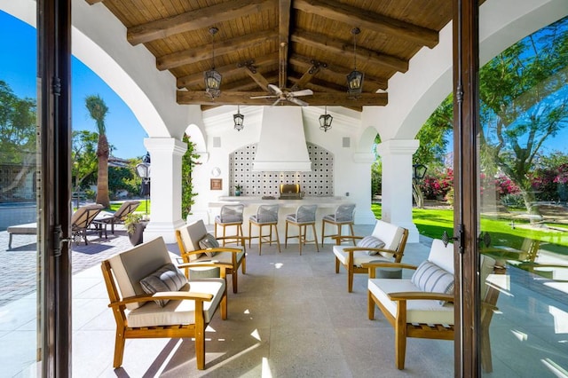 view of patio featuring a bar and ceiling fan