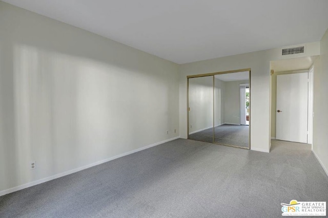 unfurnished bedroom featuring a closet and light colored carpet