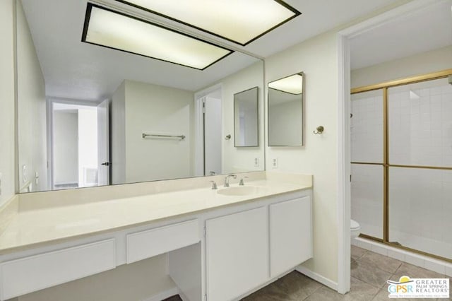 bathroom featuring tile patterned flooring, vanity, an enclosed shower, and toilet